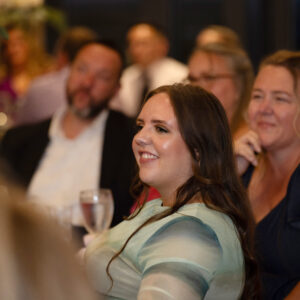 Guests smiling and enjoying a lively social event with elegant decor, creating a joyful atmosphere. Perfect setting for celebrations and gatherings where memories are made.