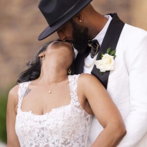 Bride and groom share a romantic moment on their wedding day wearing elegant attire with a scenic background highlighting love and celebration of a life together.