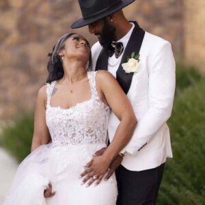 Bride and groom in elegant wedding attire share a joyful moment outdoors filled with love and happiness on their special day against a natural backdrop.