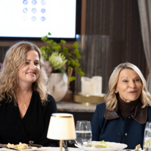 usiness professionals seated at a dining table during a corporate event.