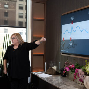 Business professional pointing to a line graph during a marketing analytics session.
