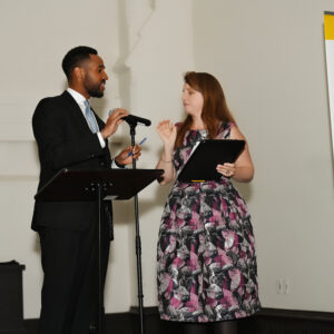 Two people speaking at a podium during a World Affairs Council event in Cincinnati Northern Kentucky. A man and woman are discussing and holding microphones.