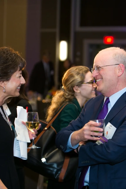 Corporate event photography showing professionals engaging in conversation indoors.