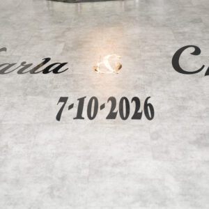 Names Karla and Che with a wedding date of July 10 2026 elegantly displayed on a light-colored marble floor, symbolizing a special event or celebration preparation.